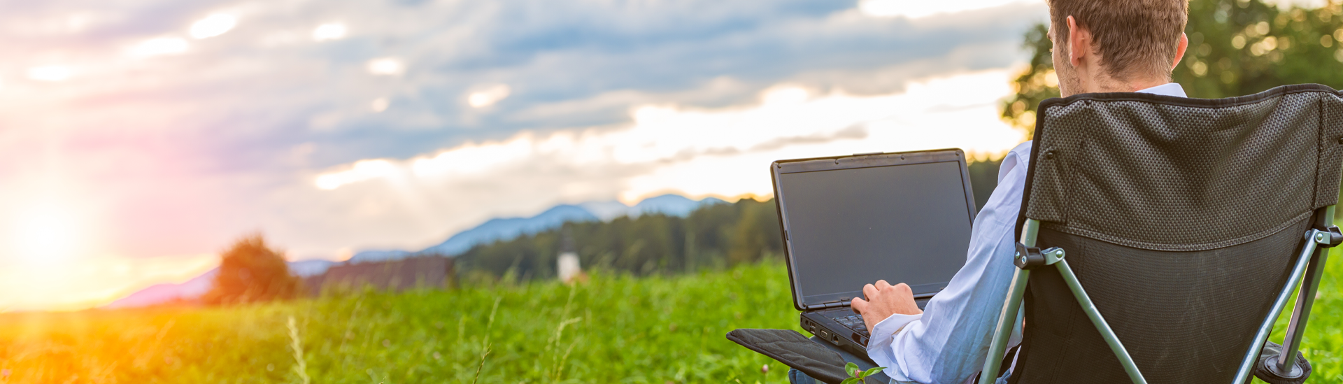 man on camp chair with labtop computer